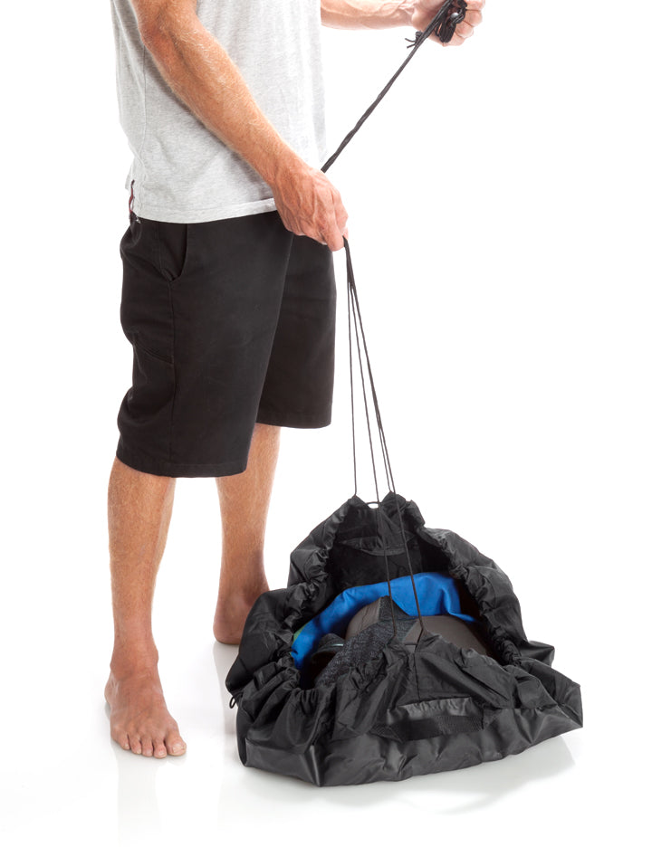 Surfer Using the Surflogic Change Mat Drawstring Bag Feature